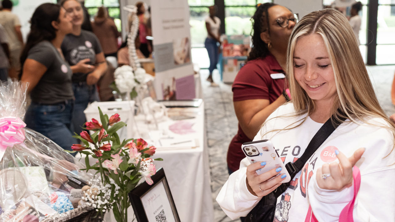 Woman taking photo with smartphone at event
