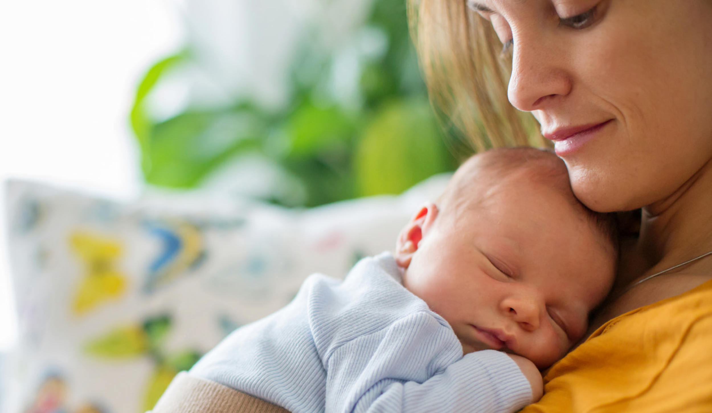 Woman holding a sleeping infant on her chest