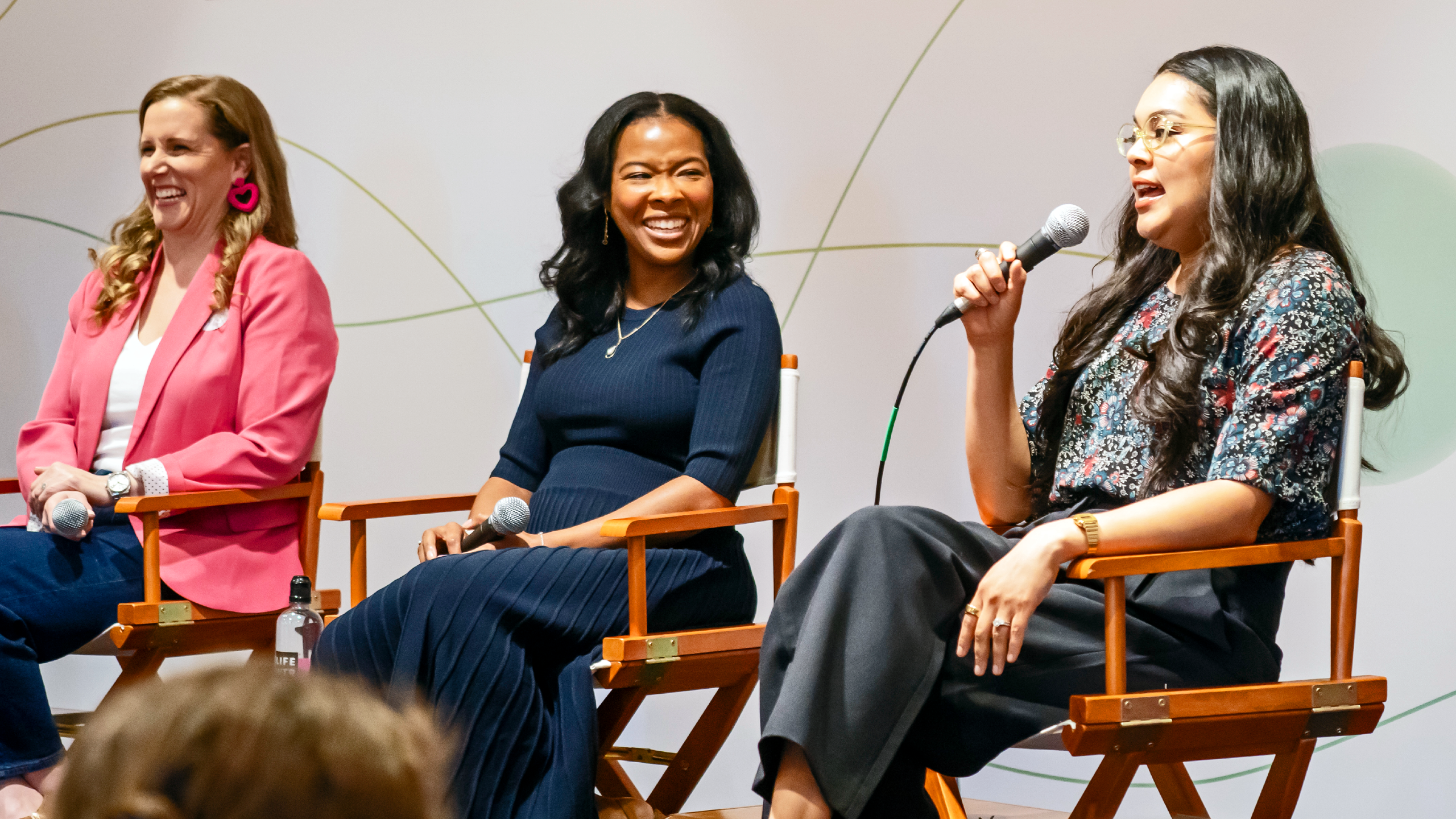 Three panelists on stage in chairs